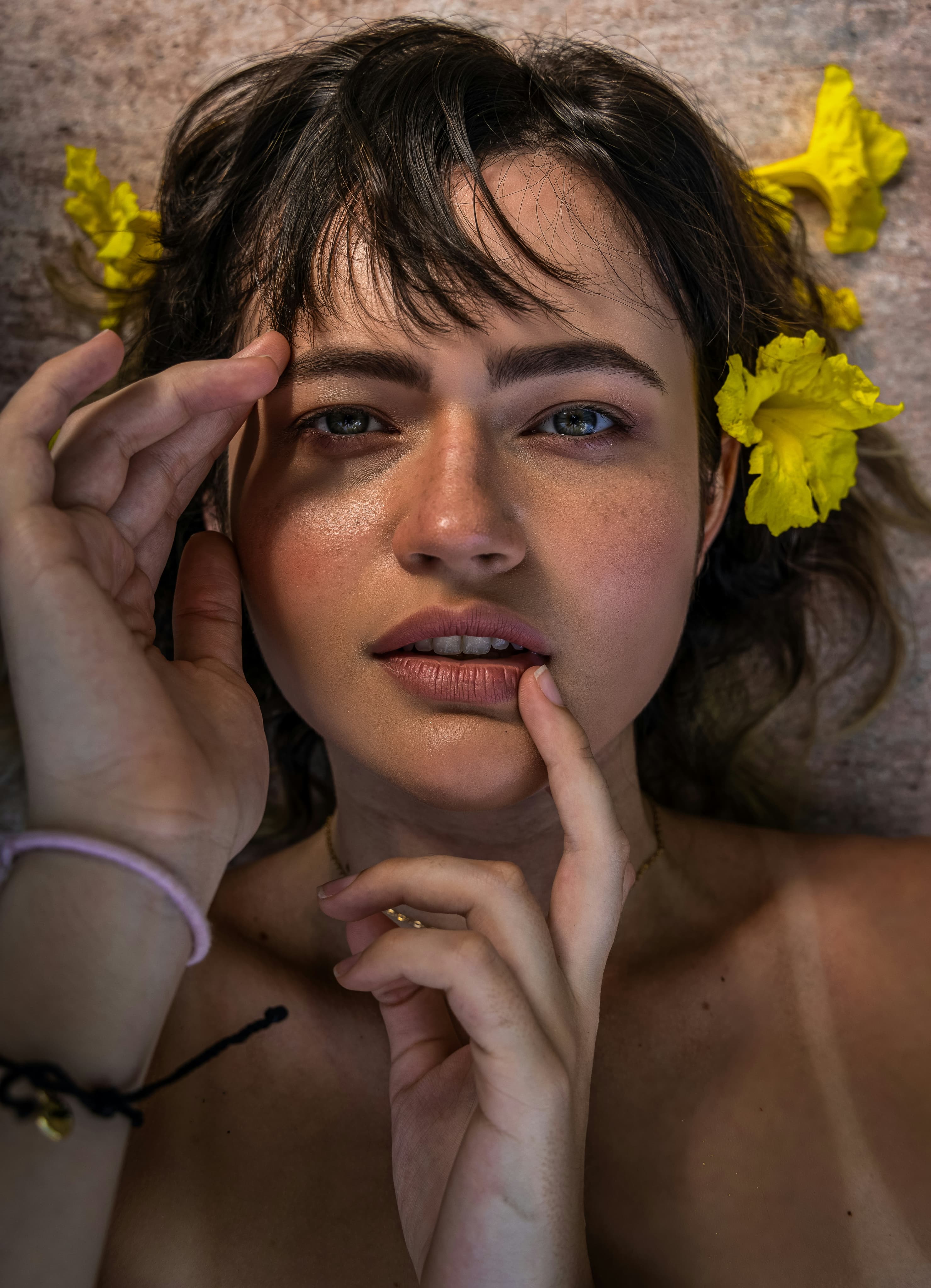 Close-up of glowing skin with soft yellow flowers framing the face