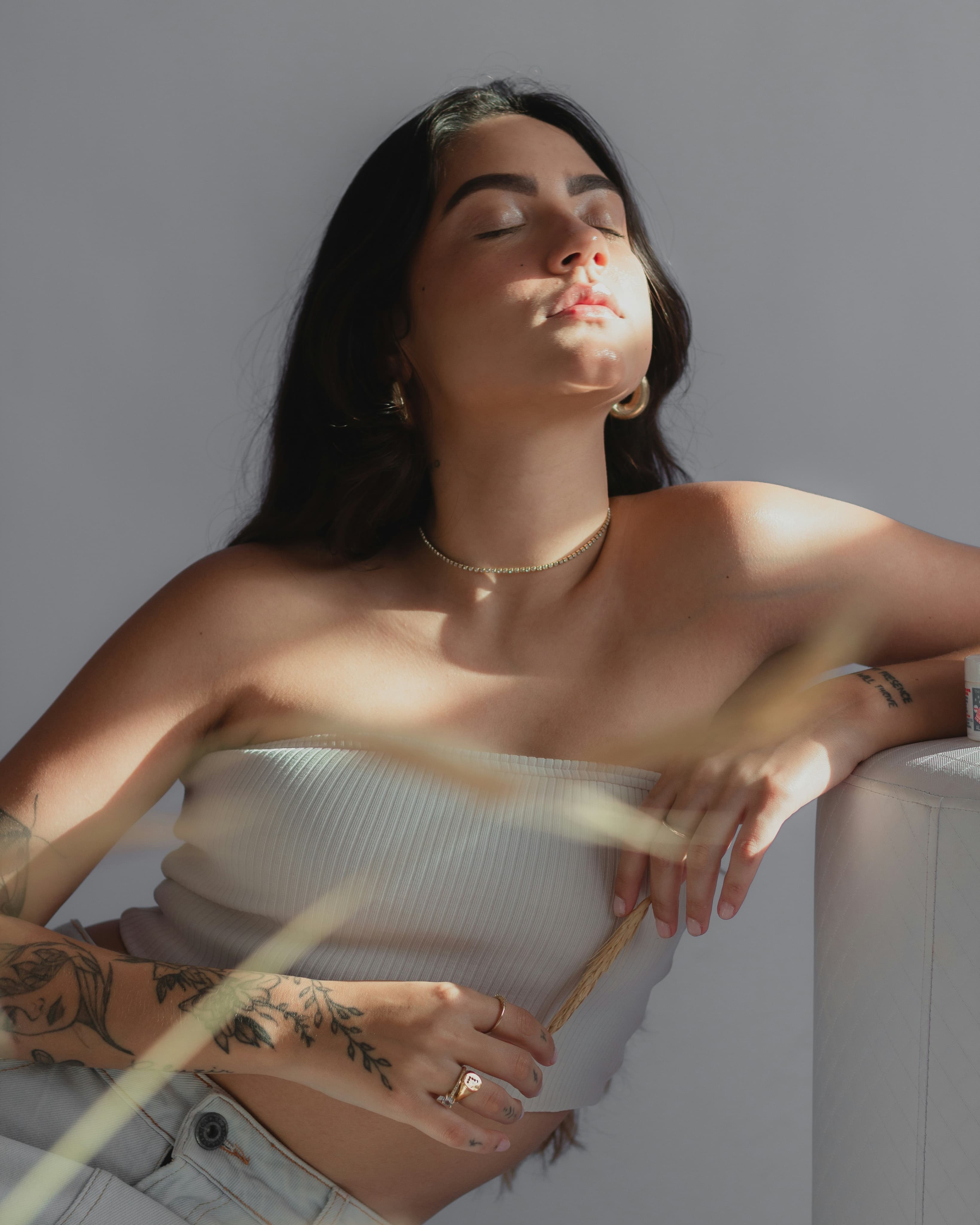 Woman with calm, sun-lit skin and closed eyes